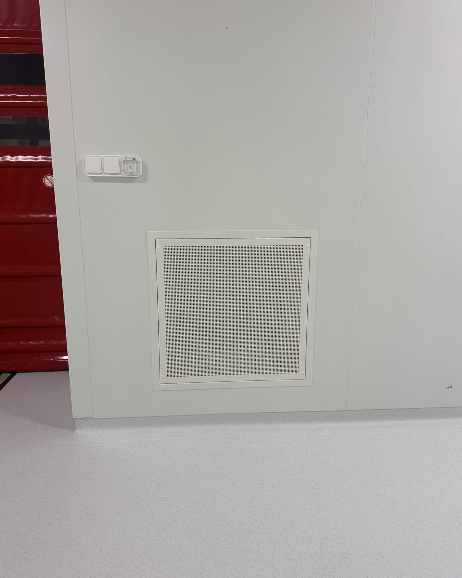 Grille de reprise d'air murale installée près d'un poste de commande dans une salle propre